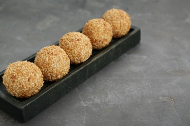 Delicious sesame balls on grey table. Space for text