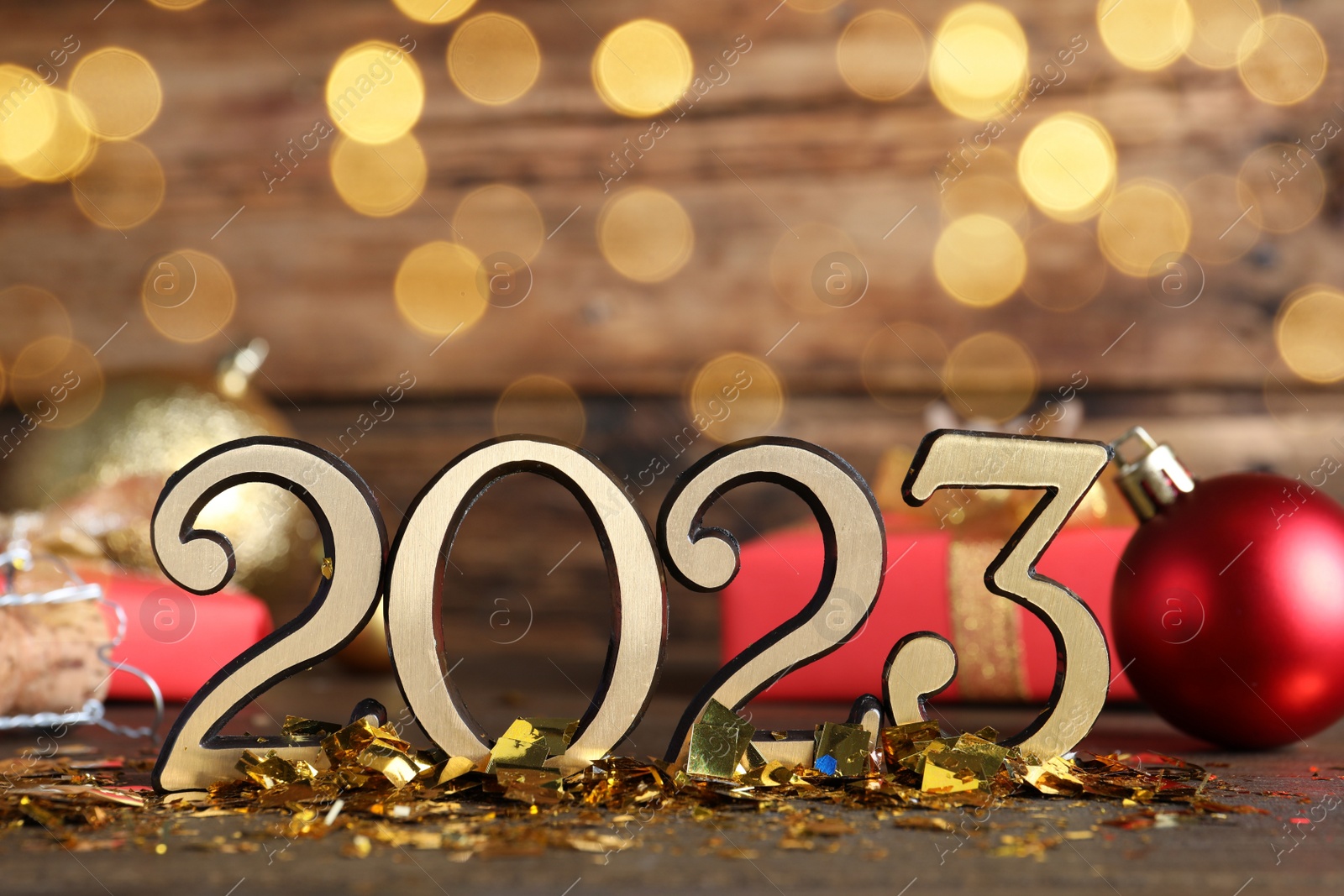 Photo of Number 2023 and festive decor on wooden table, bokeh effect. Happy New Year