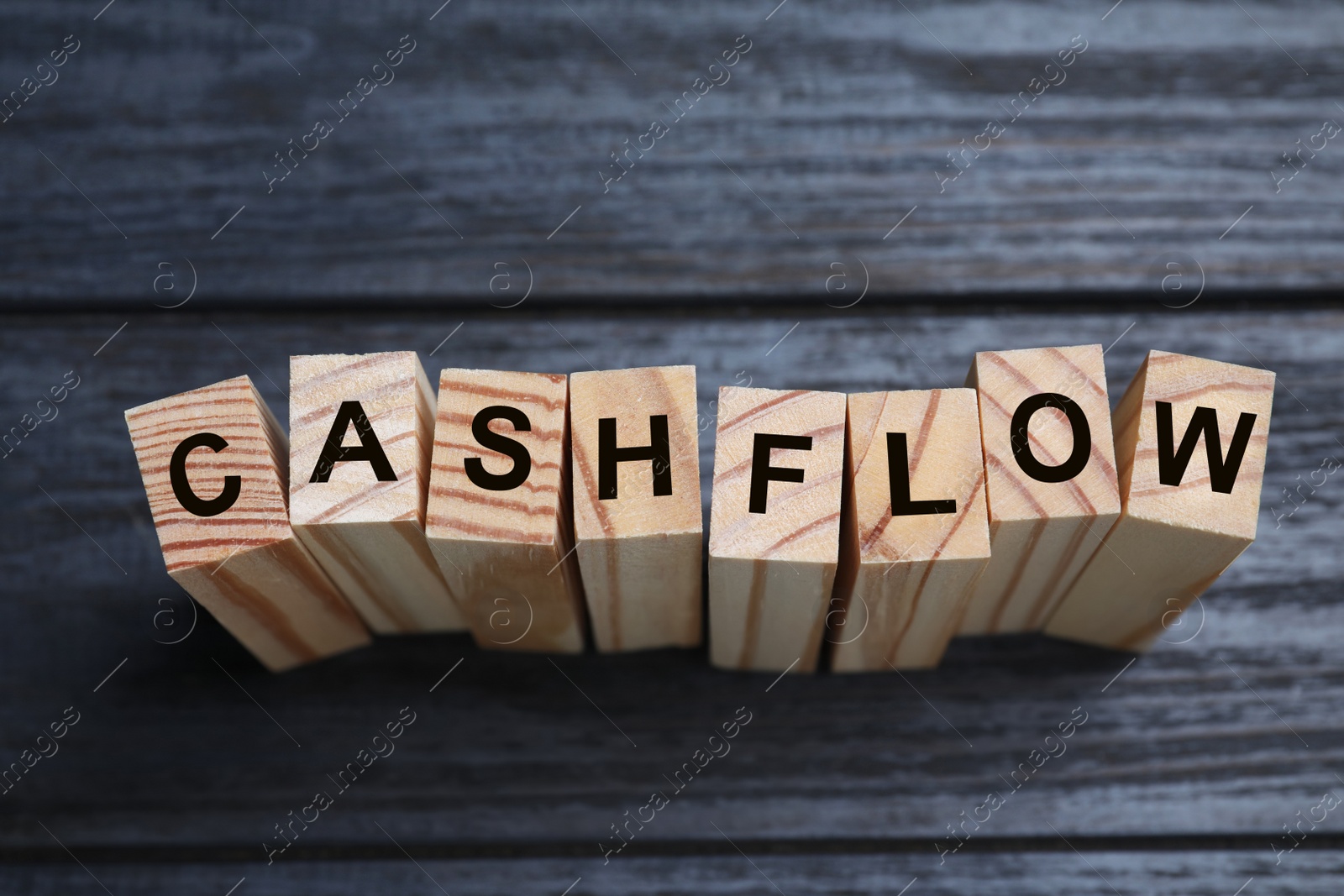 Image of Blocks with phrase Cash FLow on black wooden background, above view