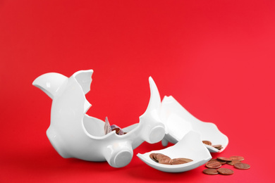 Photo of Broken piggy bank with money on red background