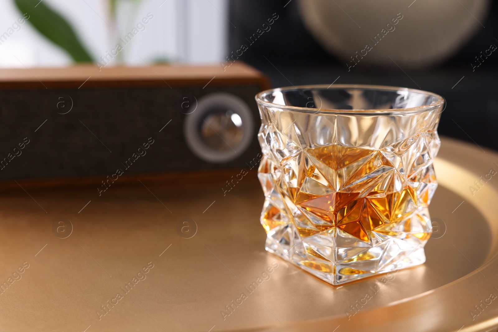 Photo of Alcohol drink on golden table in room, space for text. Relax at home