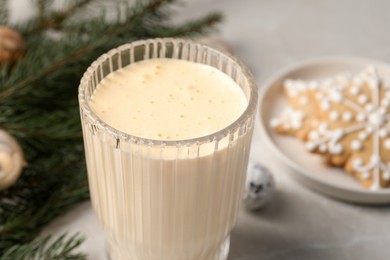 Photo of Glass of delicious eggnog on light table, closeup