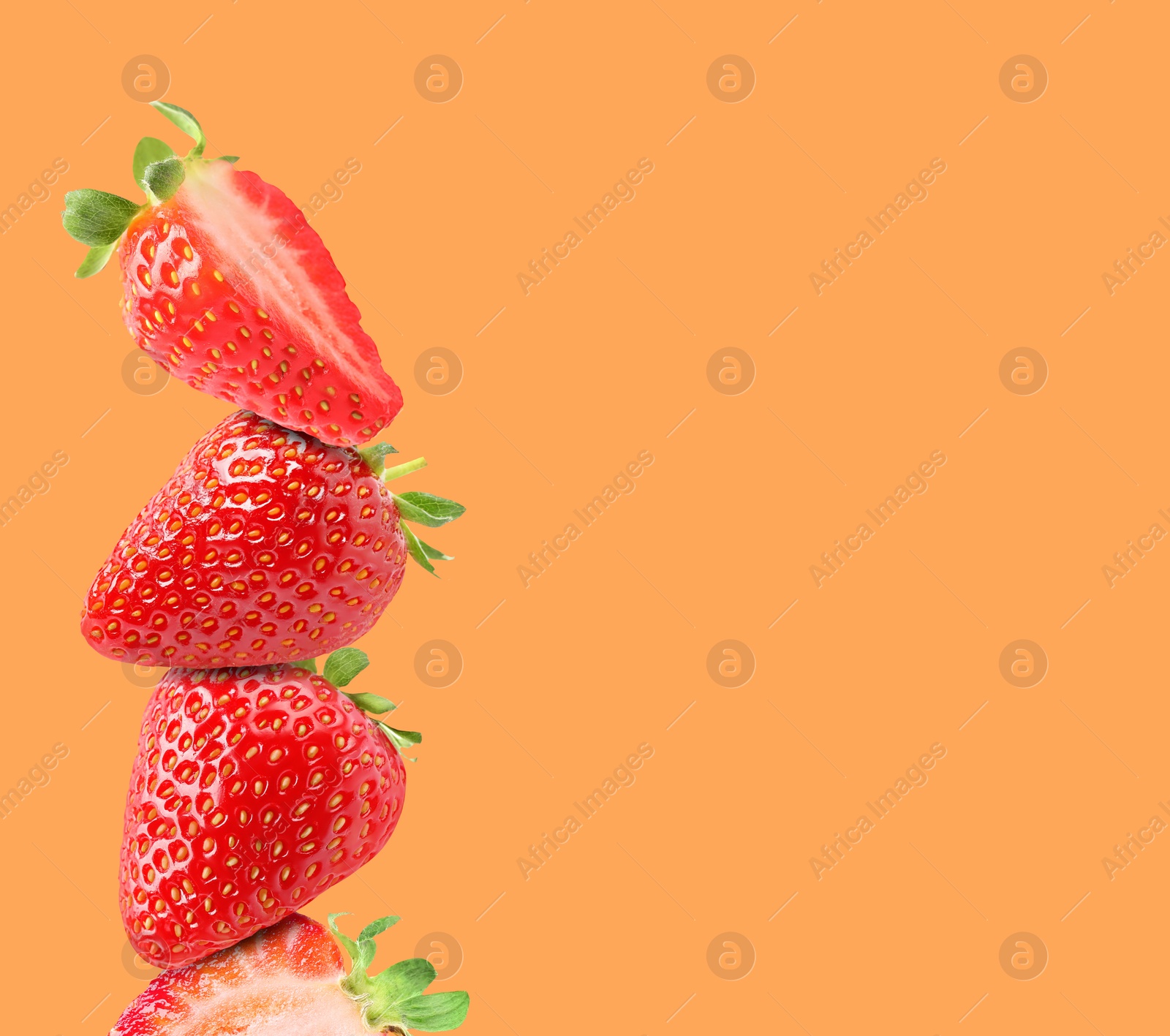 Image of Stack of fresh strawberries on orange background, space for text