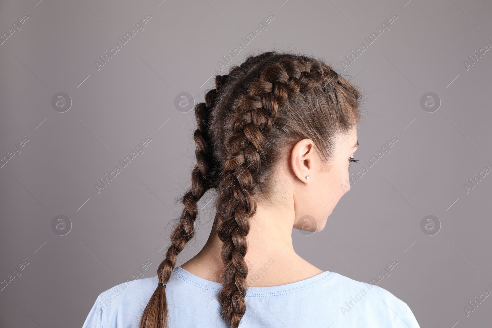 Photo of Woman with braided hair on grey background, back view