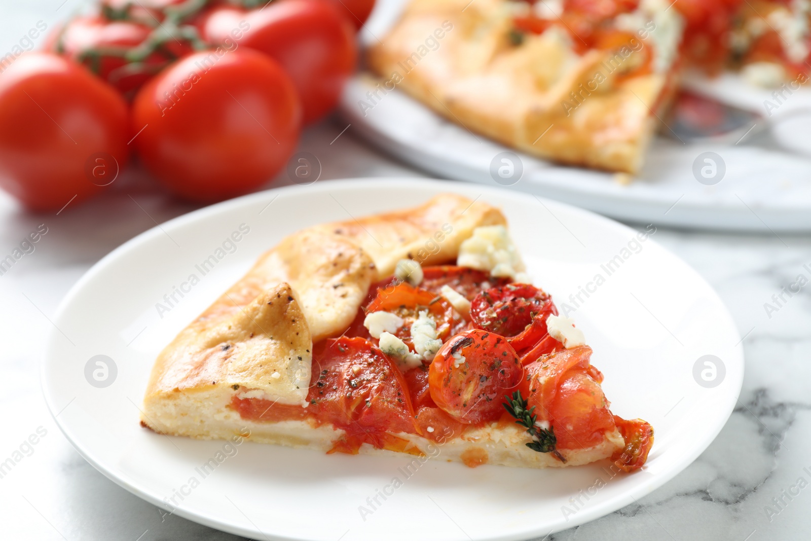 Photo of Tasty galette with tomato and cheese (Caprese galette) on white marble table, closeup