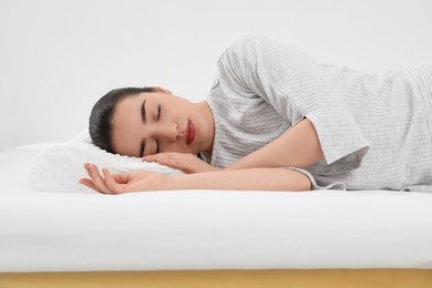 Photo of Woman sleeping on memory foam pillow indoors