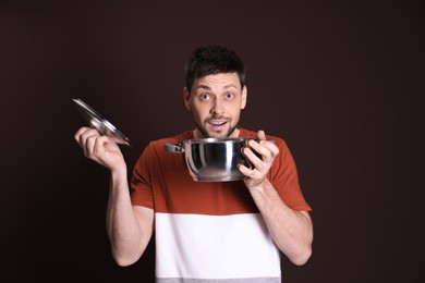 Photo of Surprised man with pot on dark background