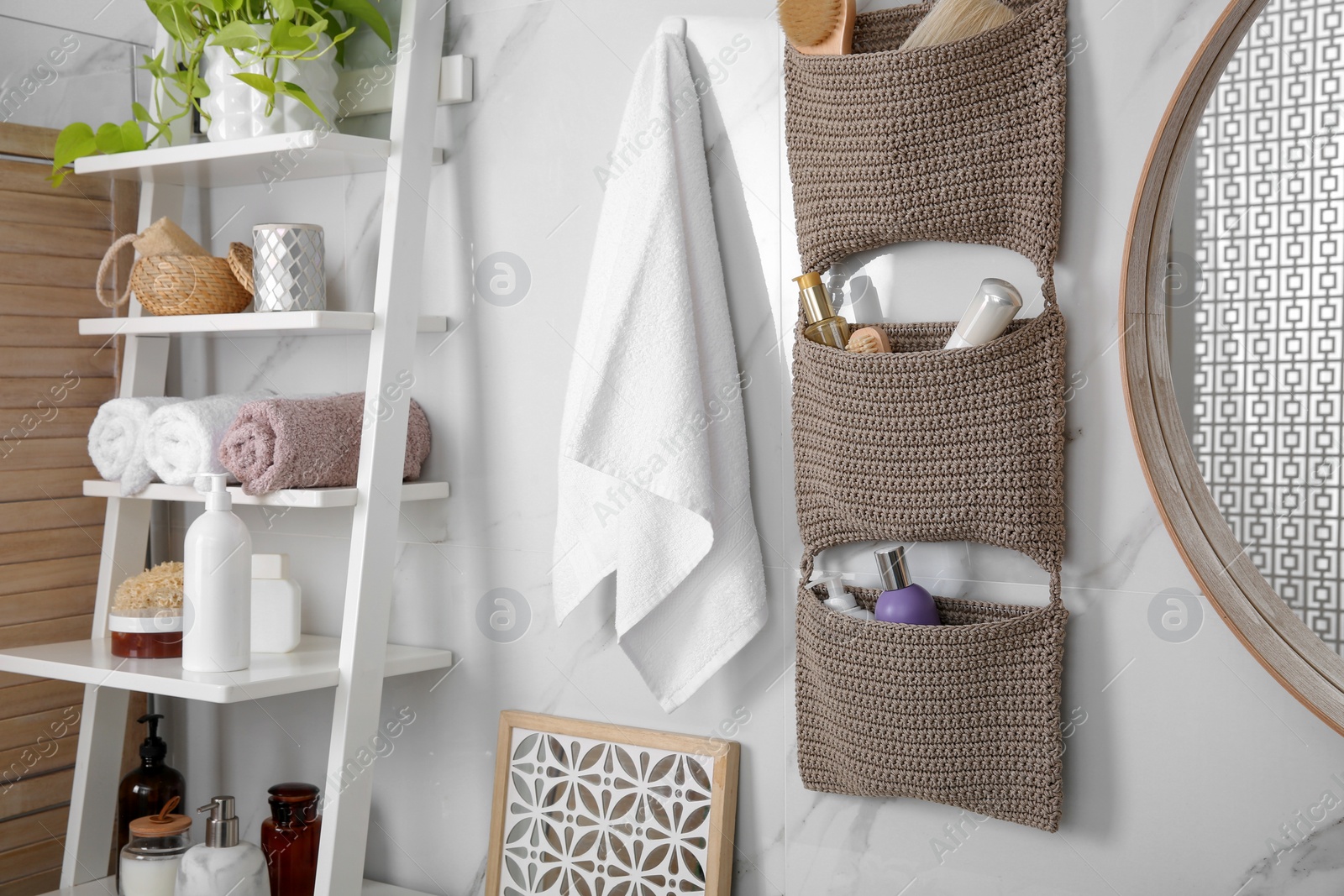 Photo of Knitted organizer hanging on wall in bathroom