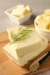 Photo of Tasty butter with dill and knife on wooden table, closeup