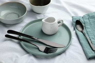 Stylish empty dishware and cutlery on table