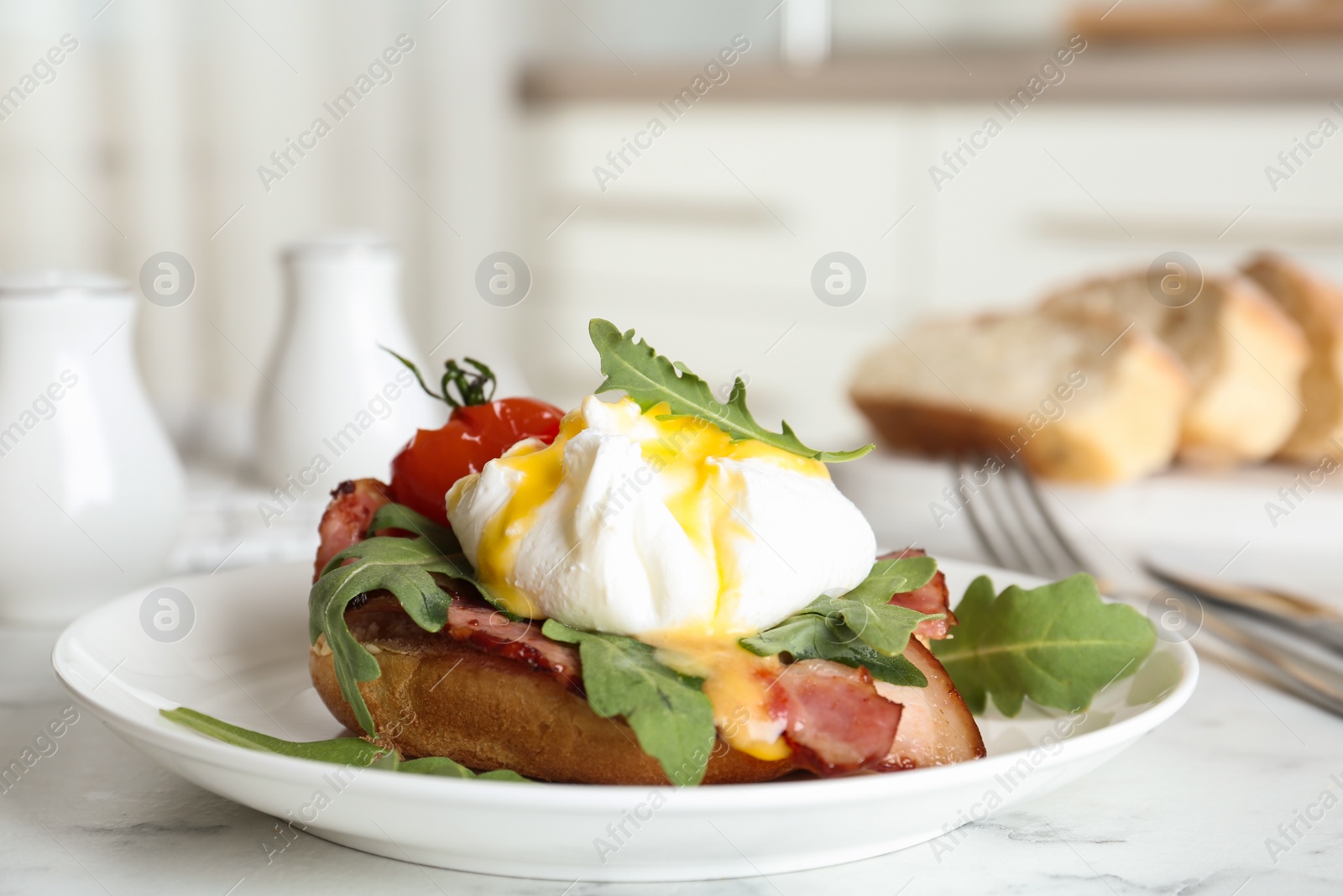 Photo of Delicious egg Benedict served on white marble table