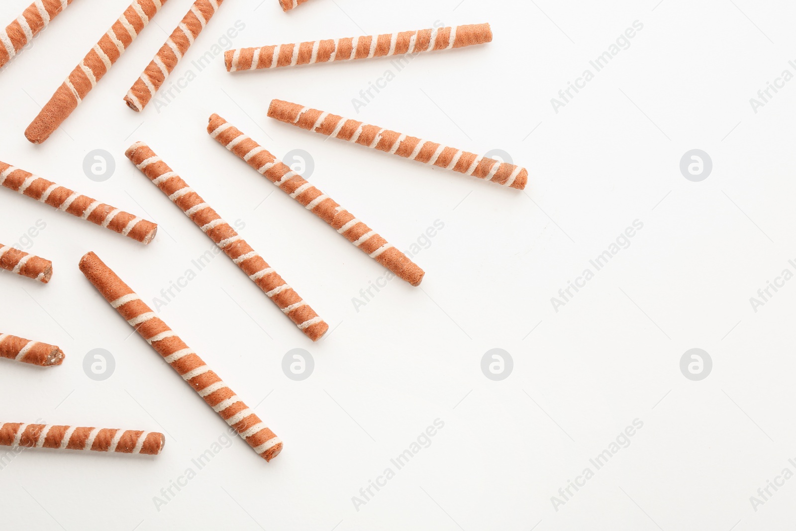 Photo of Tasty wafer roll sticks on white background, top view. Crispy food