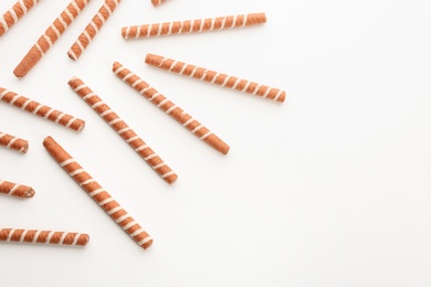 Tasty wafer roll sticks on white background, top view. Crispy food