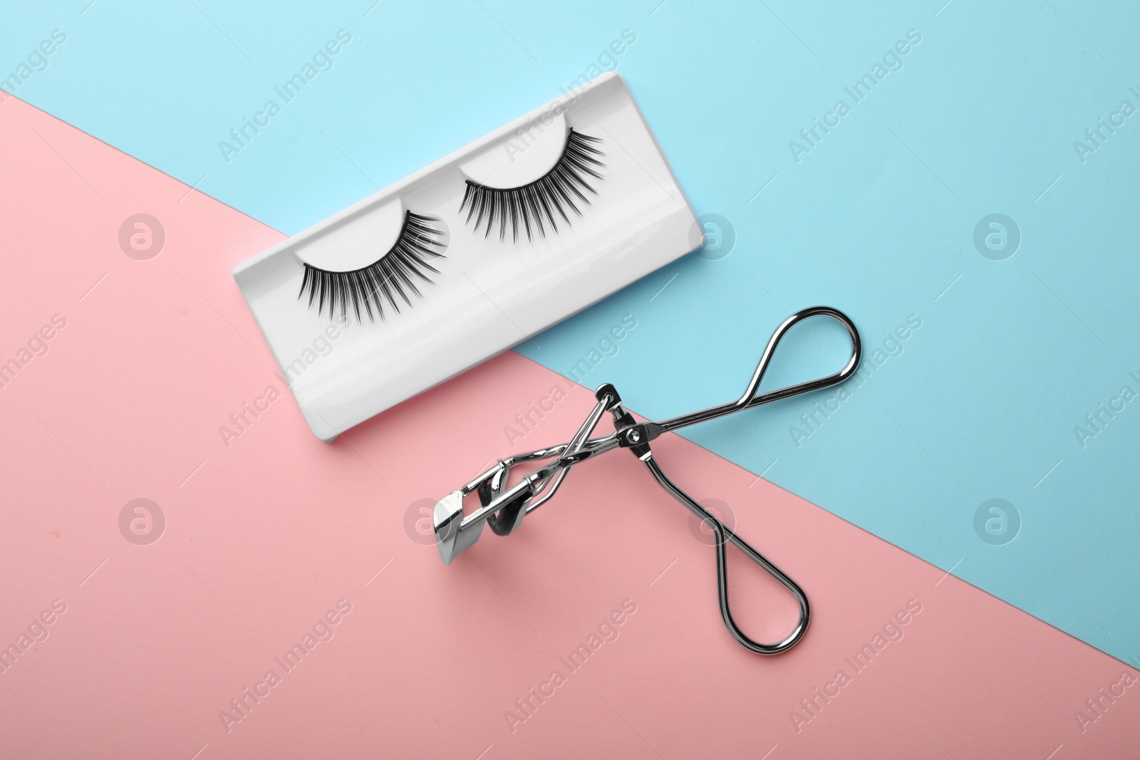 Photo of Pack with artificial eyelashes and curler on color background