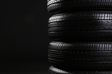 Stack of car tires on black background, closeup