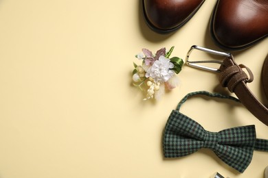 Photo of Wedding stuff. Flat lay composition with stylish boutonniere on yellow background, space for text