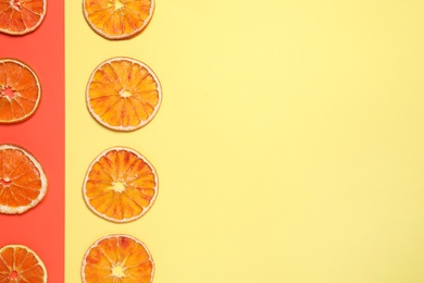 Photo of Delicious dried orange slices on color background, flat lay. Space for text