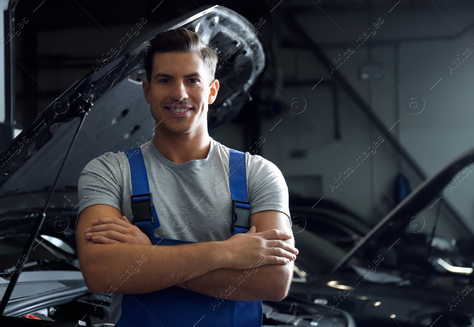 Photo of Mechanic near automobile in service center. Modern car diagnostic