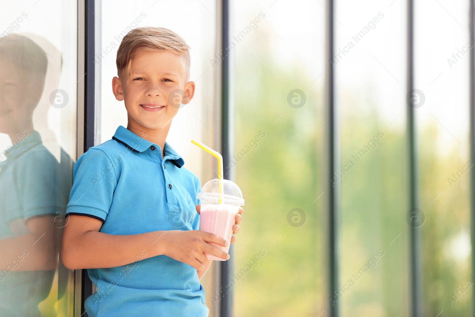 Photo of Little boy with cup of milk shake outdoors