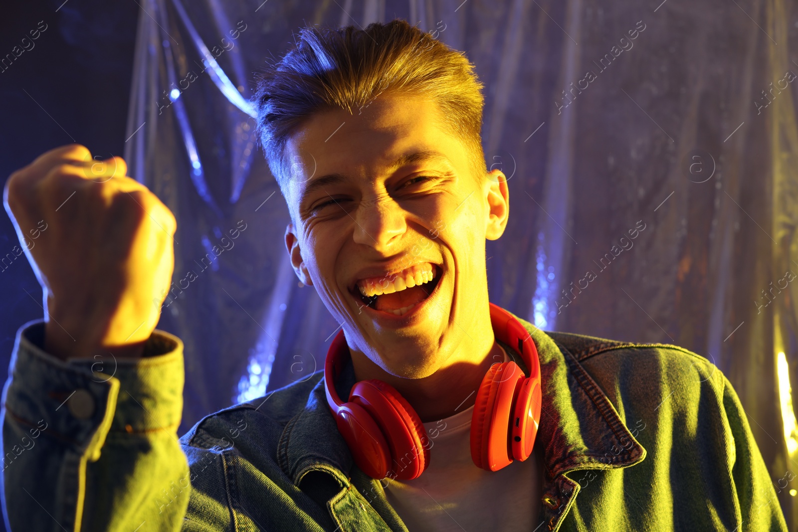 Photo of Young man with headphones in neon lights