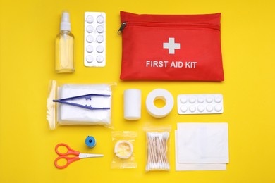 Photo of Flat lay composition with first aid kit on yellow background