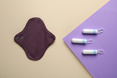 Photo of Reusable cloth menstrual pad and tampons on color background, flat lay