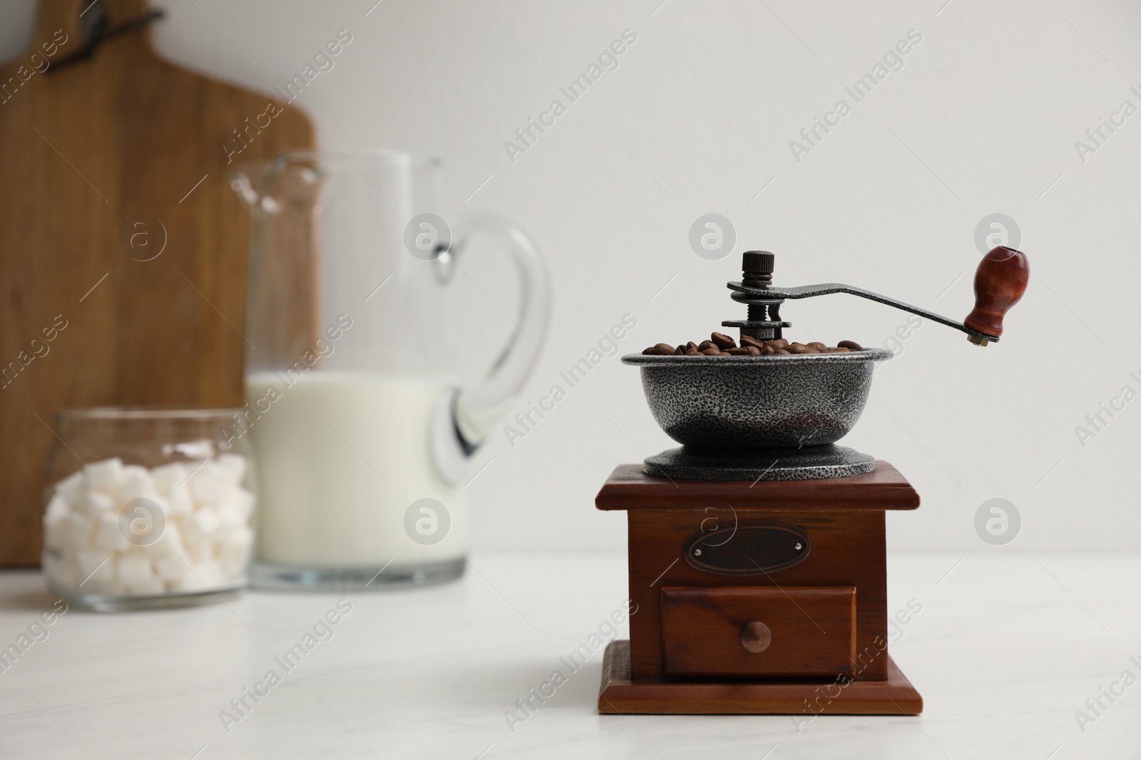 Photo of Vintage manual coffee grinder with beans on counter in kitchen