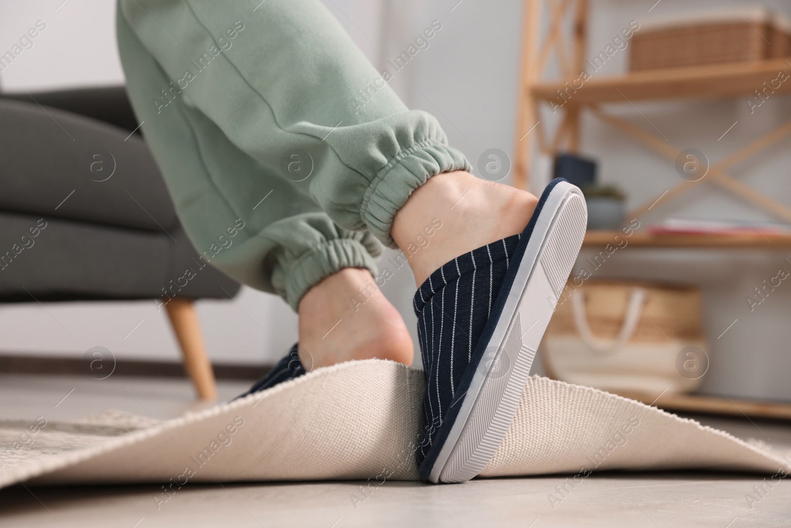 Photo of Man tripping over rug at home, closeup