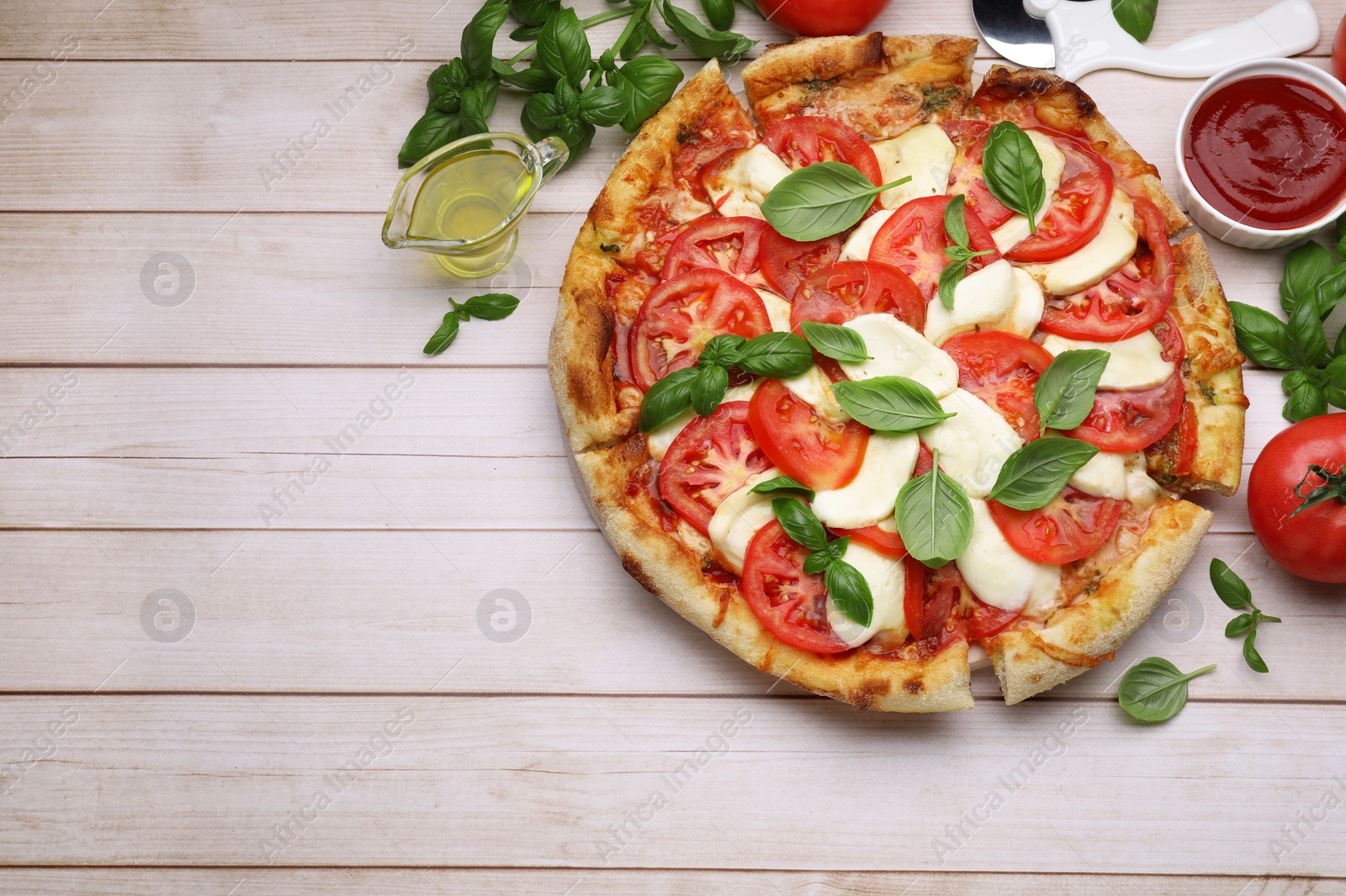 Photo of Delicious Caprese pizza with tomatoes, mozzarella and basil served on light wooden table, flat lay. Space for text