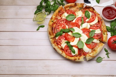 Delicious Caprese pizza with tomatoes, mozzarella and basil served on light wooden table, flat lay. Space for text