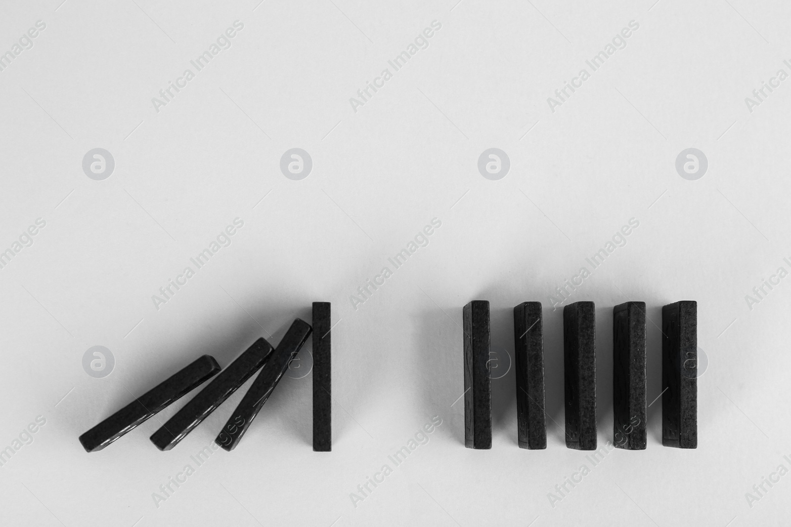 Photo of Black domino tiles on white background, flat lay. Space for text