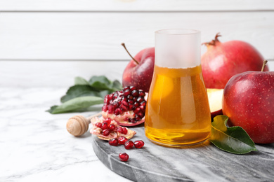 Honey, apples and pomegranate on white marble table. Rosh Hashanah holiday