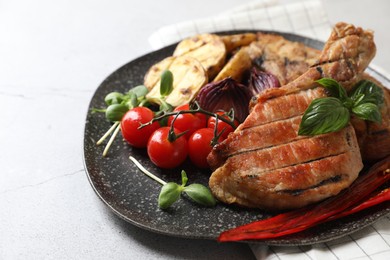 Photo of Delicious grilled meat and vegetables on light grey table, closeup