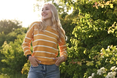 Portrait of happy young woman in park on spring day