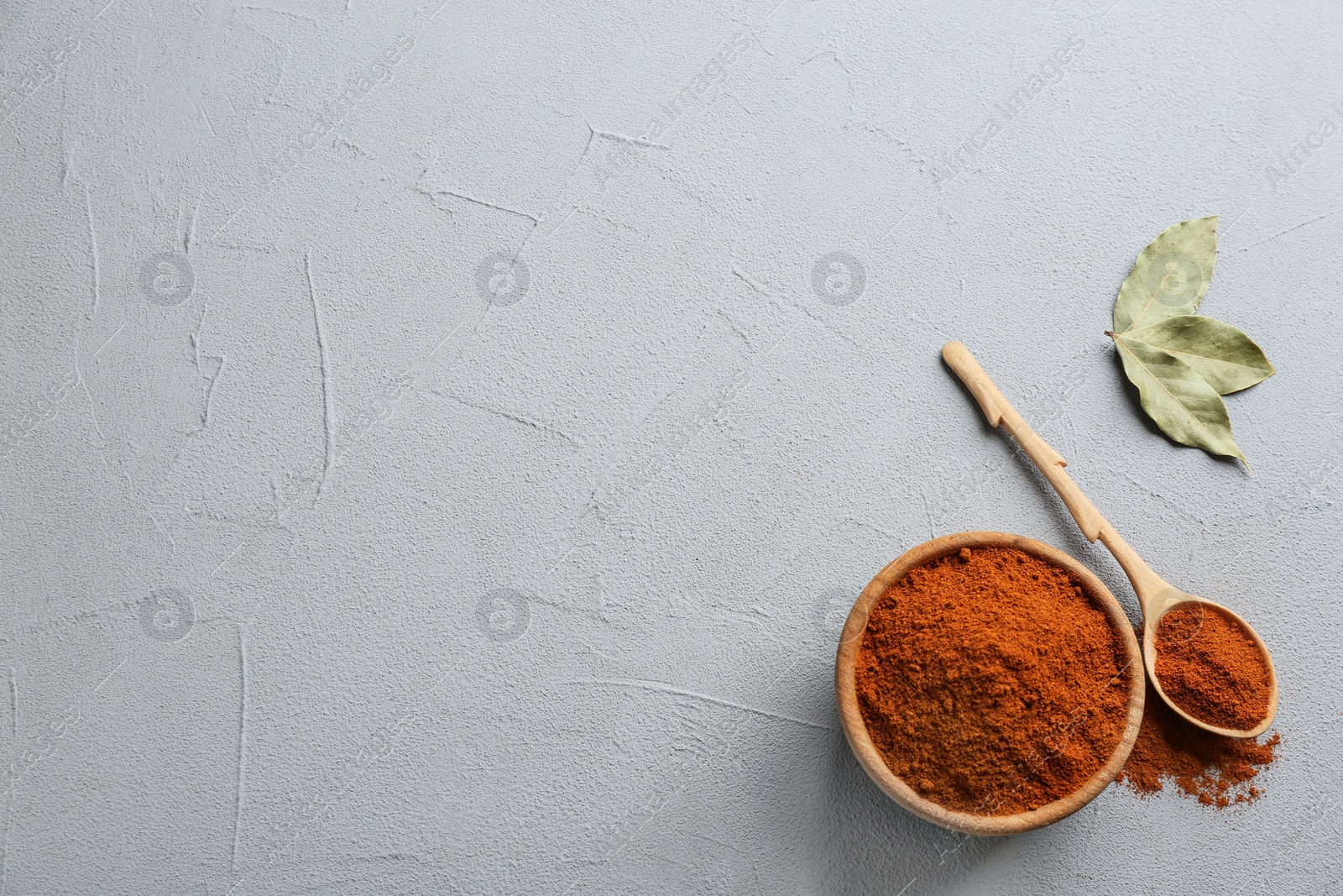 Photo of Ground red pepper on grey table, top view. Space for text