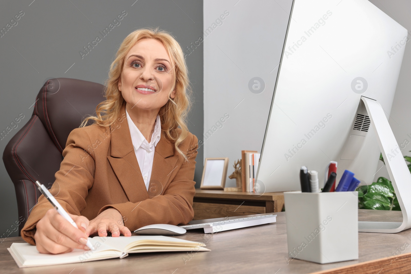 Photo of Lady boss working near computer at desk in office. Successful businesswoman