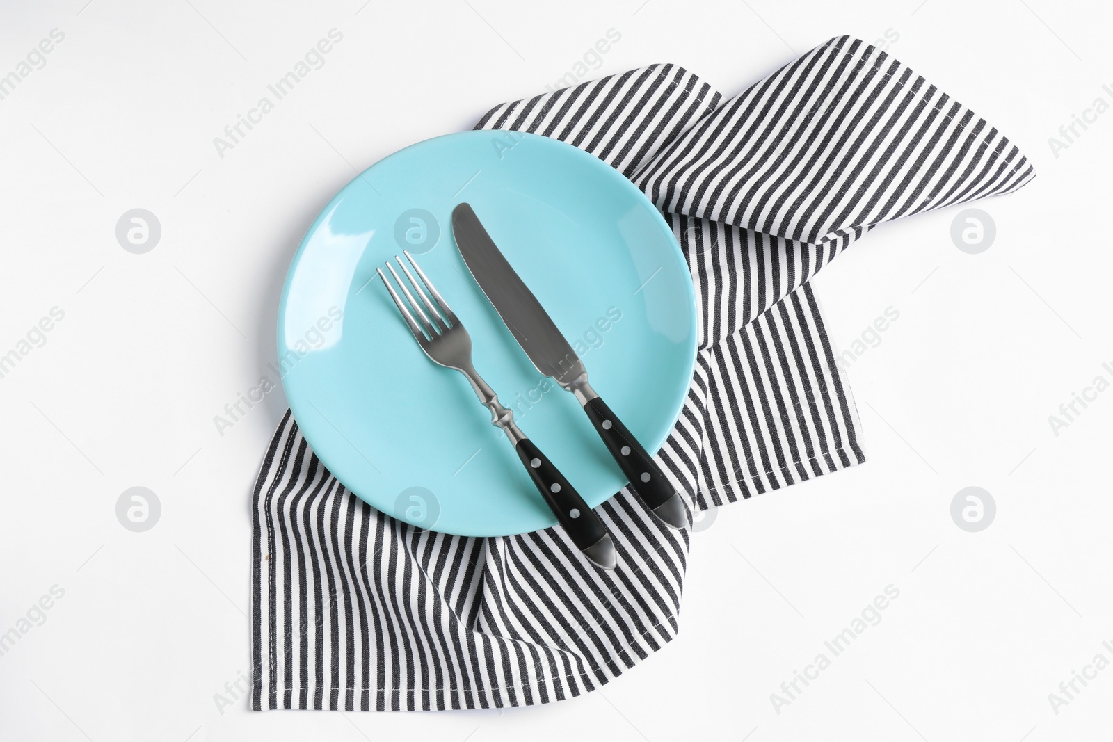 Photo of Plate, fork and knife on white background, top view