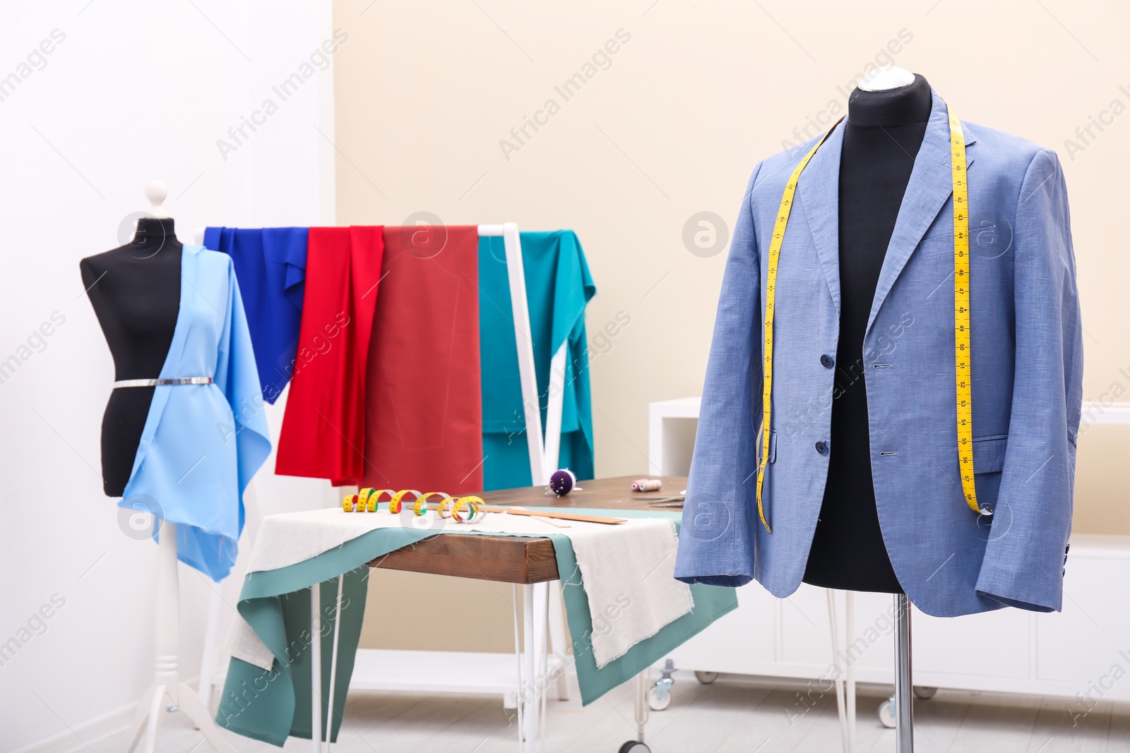 Photo of Mannequin with jacket and measuring tape in tailor studio