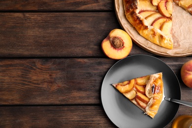 Delicious fresh peach pie served on wooden table, flat lay. Space for text