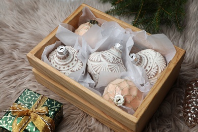 Photo of Composition with beautiful Christmas baubles on beige fur