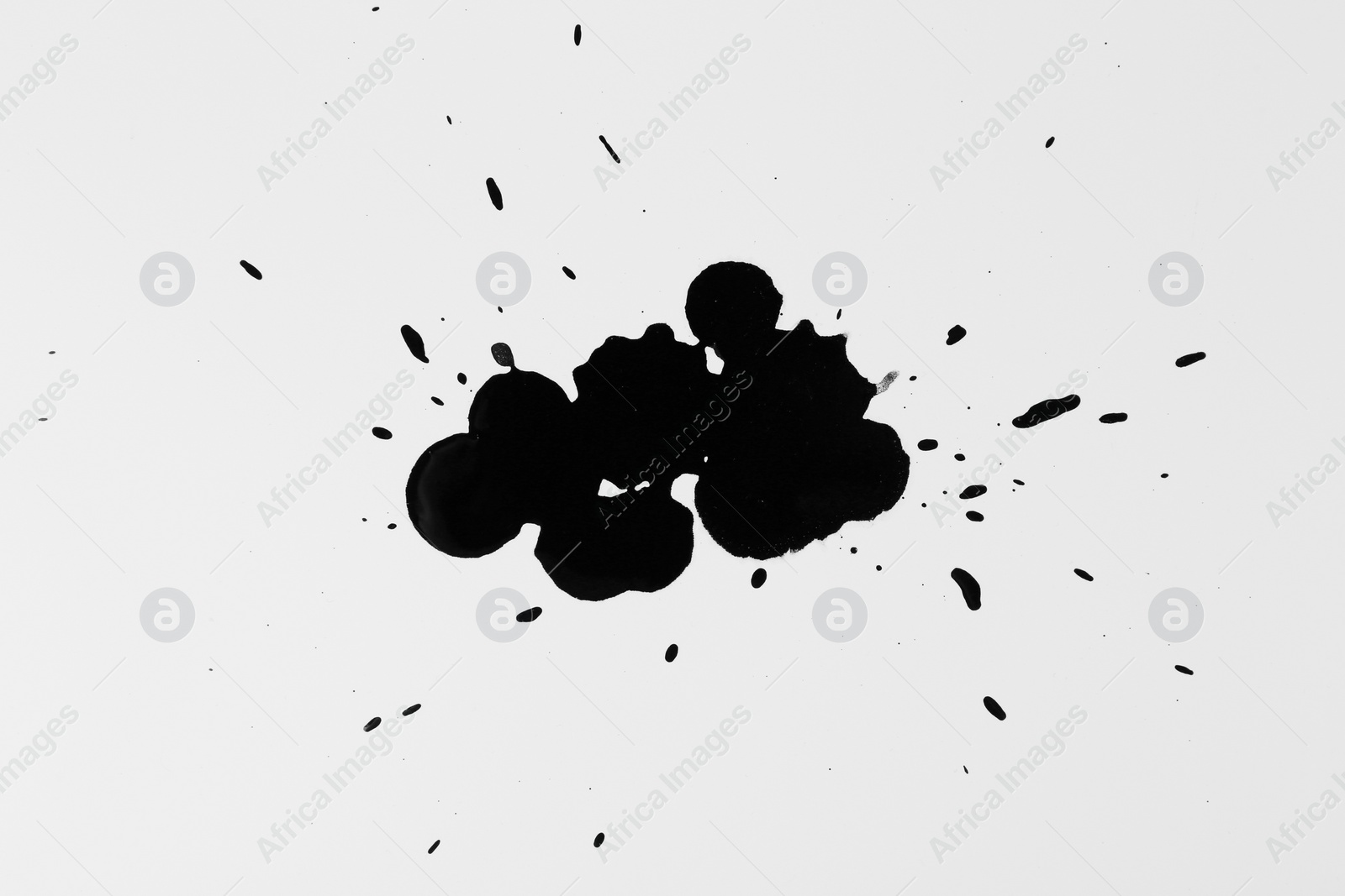 Photo of Blots of black ink on white background, top view