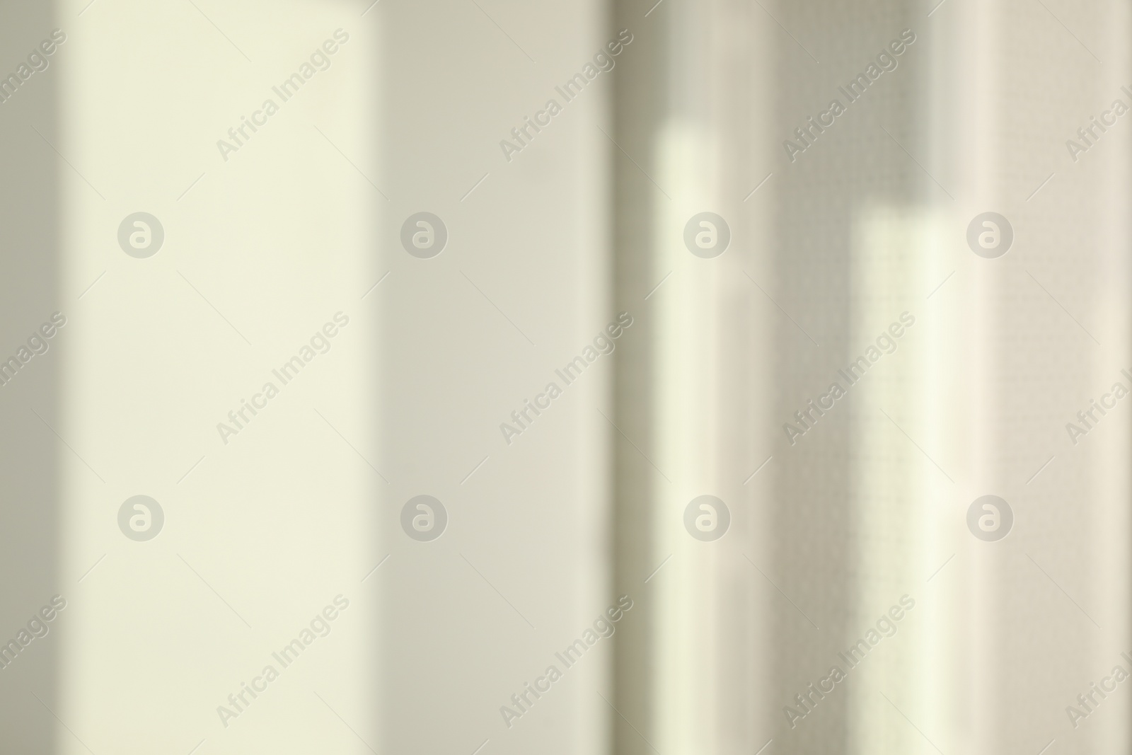 Photo of Blurred view of light and shadows from window on wall indoors