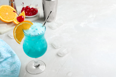 Photo of Tasty Blue Lagoon cocktail on light grey table. Space for text