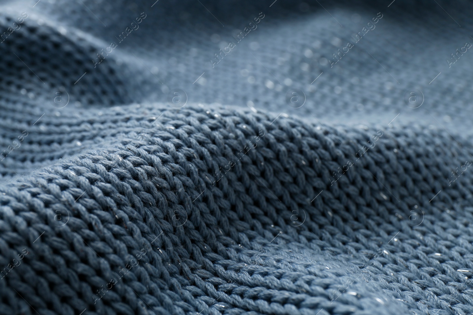 Photo of Beautiful pale blue knitted fabric as background, closeup