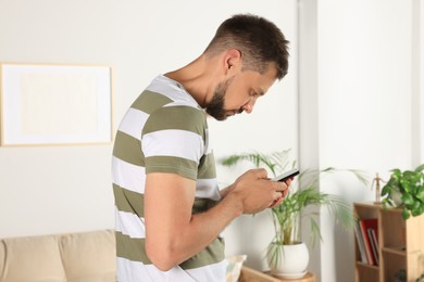 Photo of Man with poor posture using smartphone at home