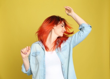 Photo of Young woman with bright dyed hair on yellow background