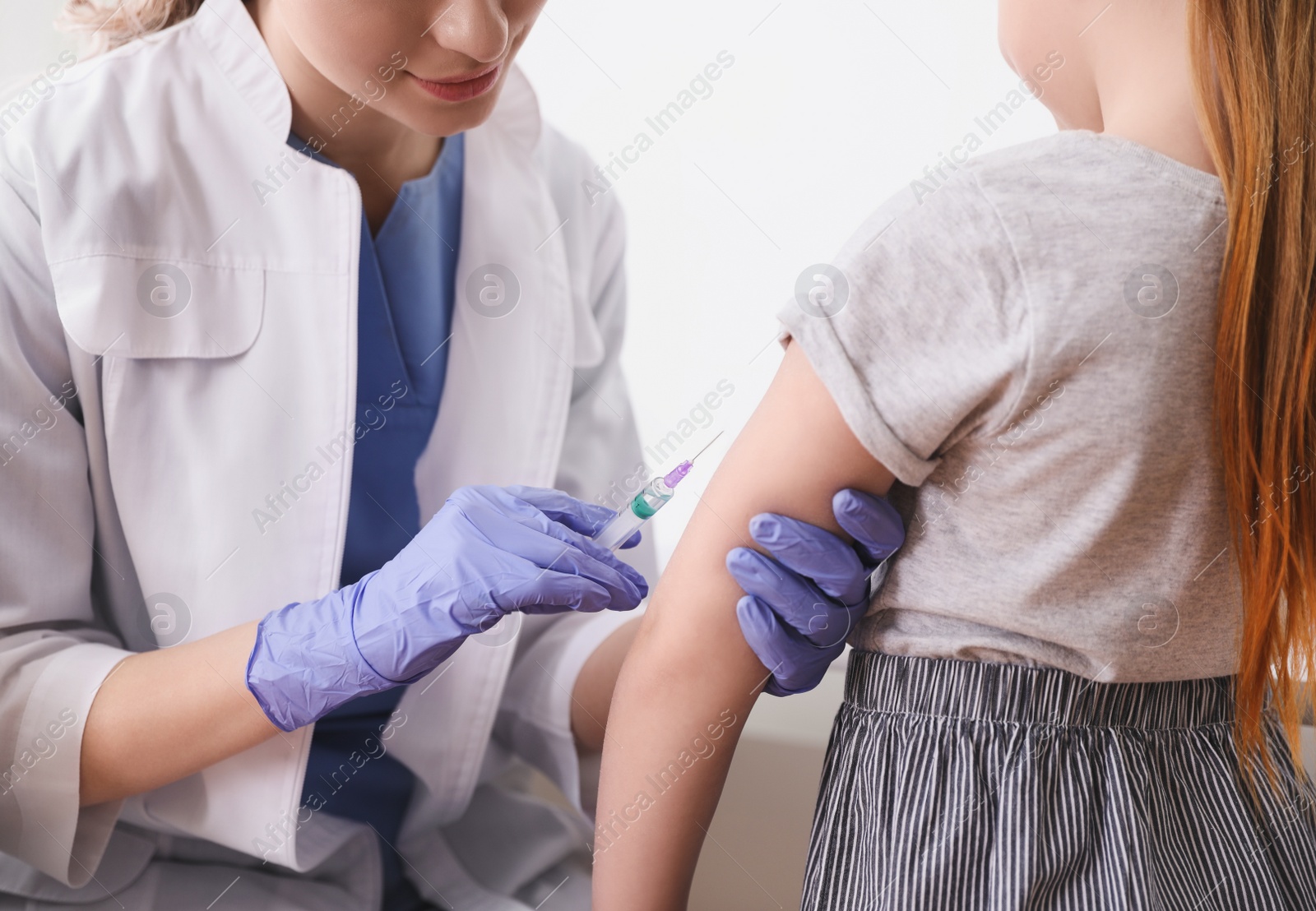 Photo of Little girl receiving chickenpox vaccination in clinic, closeup. Varicella virus prevention