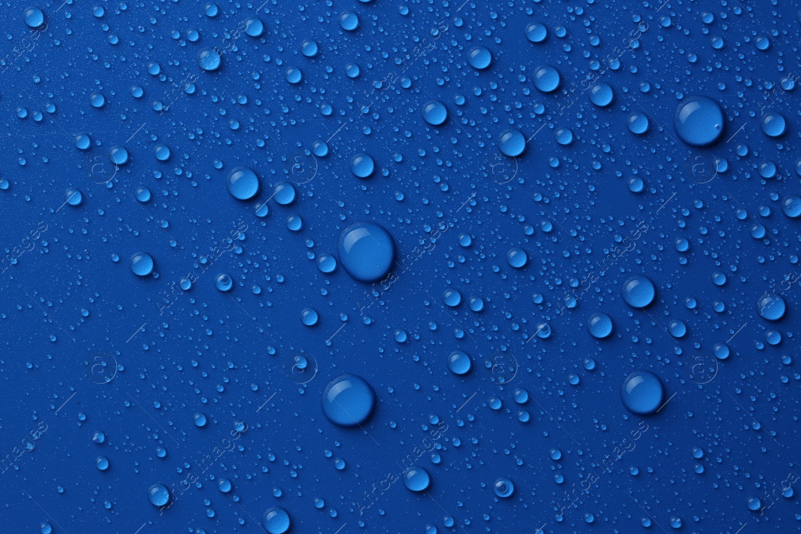 Photo of Water drops on blue background, top view