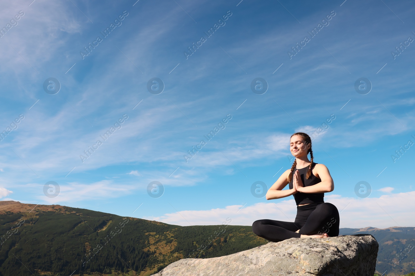 Photo of Young woman practicing outdoor yoga in mountains, space for text. Fitness lifestyle