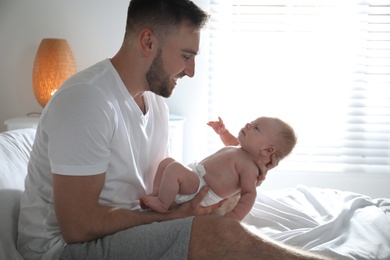 Photo of Father with his newborn son at home